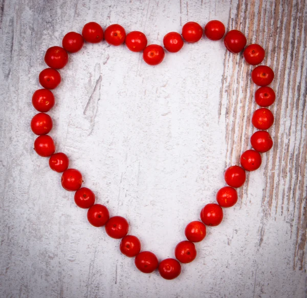 Heart of red viburnum on old wooden background — Stock Photo, Image