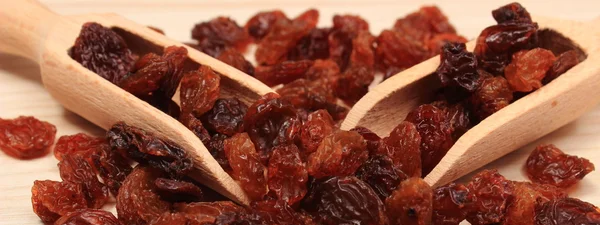 Raisins marron avec cuillère sur table en bois, saine alimentation — Photo