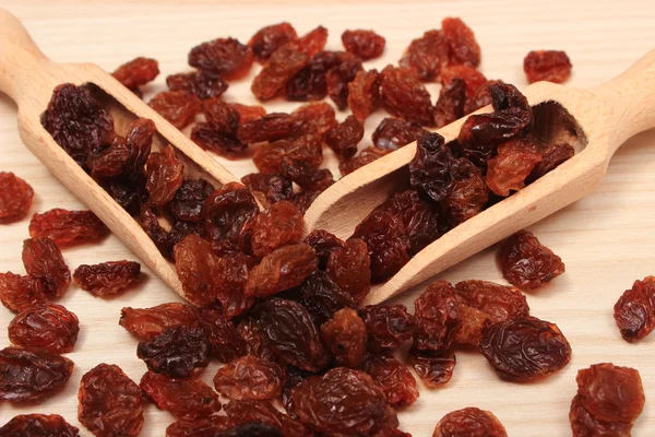 Raisins marron avec cuillère sur table en bois, saine alimentation — Photo