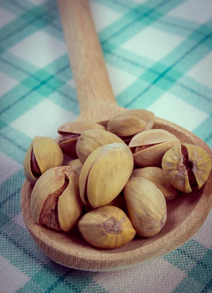 Foto vintage, Nueces de pistacho con cuchara en mantel a cuadros, alimentación saludable —  Fotos de Stock