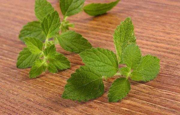 Verse gezonde Citroenmelisse op houten tafel, fytotherapie — Stockfoto