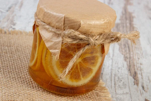 木製のテーブル、健康な栄養物のガラスの瓶に蜂蜜とレモン — ストック写真