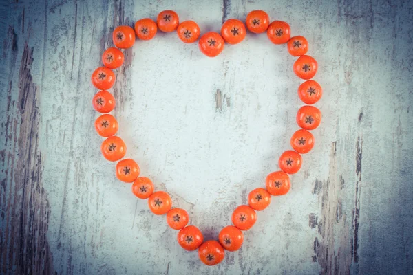 Foto vintage, Corazón de rojo rowan otoño sobre fondo de madera — Foto de Stock