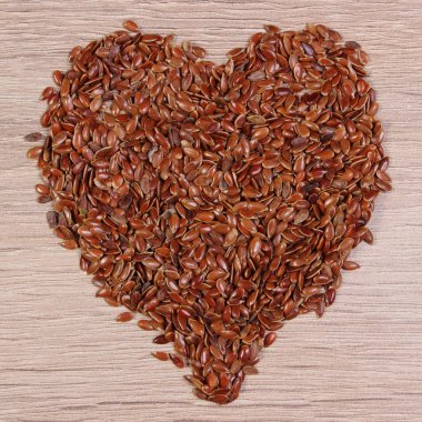 Heart of linseed on wooden background