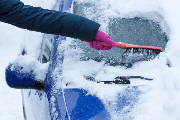 Hand der Frau mit Pinsel und Schnee von Auto und Windschutzscheibe entfernen — Stockfoto