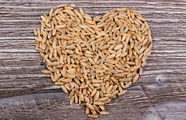 Heart of rye grain on wooden background — Stock Photo, Image