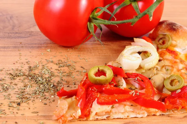 Scheibe vegetarische Pizza, Tomaten und Gewürze auf Holzoberfläche — Stockfoto