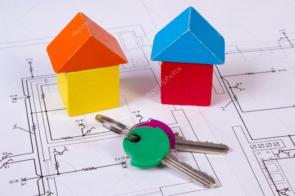 Houses of wooden blocks and keys on construction drawing of house, building house concept