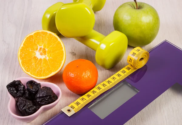 Escala digital con cinta métrica, mancuernas, frutas, concepto de adelgazamiento — Foto de Stock