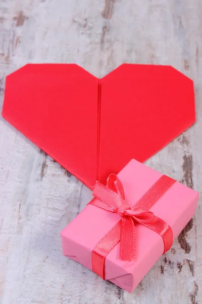 Regalo envuelto para cumpleaños, San Valentín u otra celebración y corazón rojo — Foto de Stock