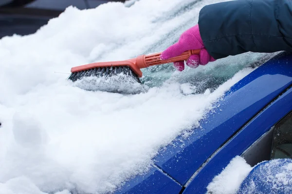 Mão de mulher usando escova e remover a neve do carro e pára-brisas — Fotografia de Stock