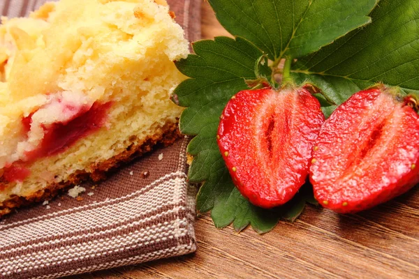 Fresh strawberries with leaves and piece of yeast cake — Stock Photo, Image