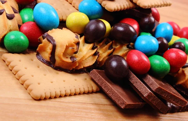Una gran cantidad de dulces en la superficie de madera, alimentos poco saludables — Foto de Stock