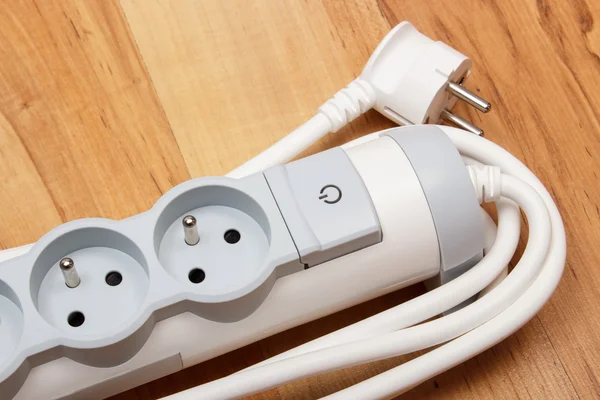 Electrical power strip with switch on-off on wooden floor — Stock Photo, Image