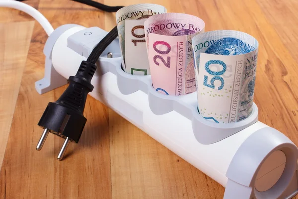 Rolls of polish currency money in electrical power strip and disconnected plug, energy costs — Stock Photo, Image