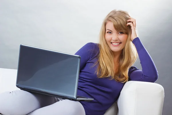 ソファ、モダンな技術の上に座ってラップトップを使用して幸せな女 — ストック写真