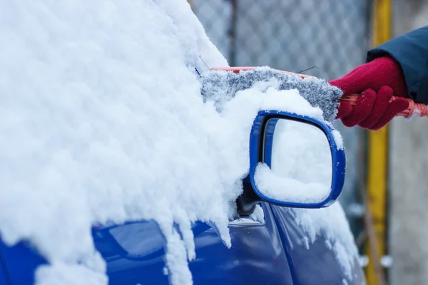 Ręka kobiety za pomocą pędzla i usunąć śnieg z samochodu i lustro — Zdjęcie stockowe
