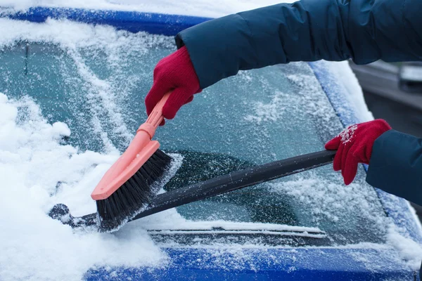 Hand of woman using brush and remove snow from car and windscreen — Stock Photo, Image