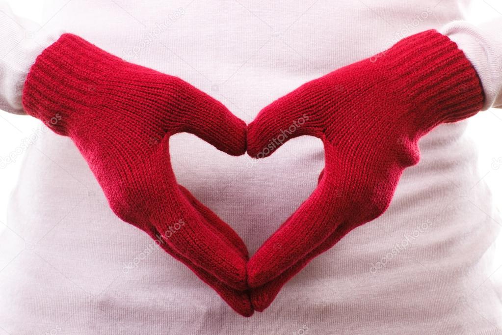 Hand in woolen gloves arranged in shape of heart, symbol of love