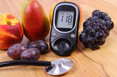 Glucose meter with medical stethoscope and fresh fruits, healthy lifestyle