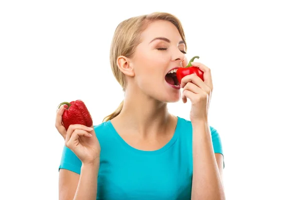 Kvinnan håller skrynklig paprika och äta färsk mogen paprika, vit bakgrund — Stockfoto