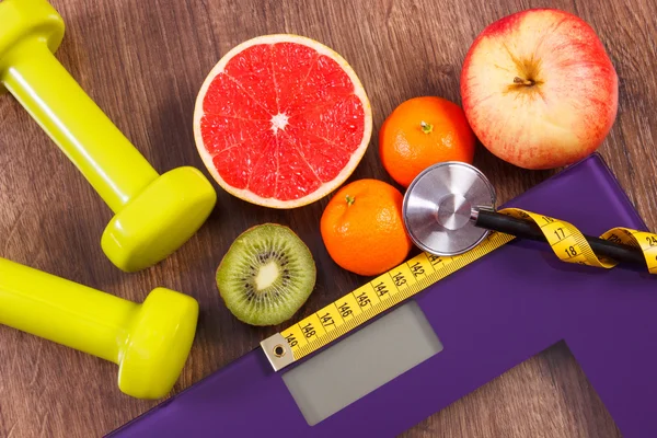 Elektronische Badezimmerwaage, Zentimeter und Stethoskop, frisches Obst, Kurzhanteln für Fitness, Schlankheits- und gesundes Lebensstilkonzept — Stockfoto