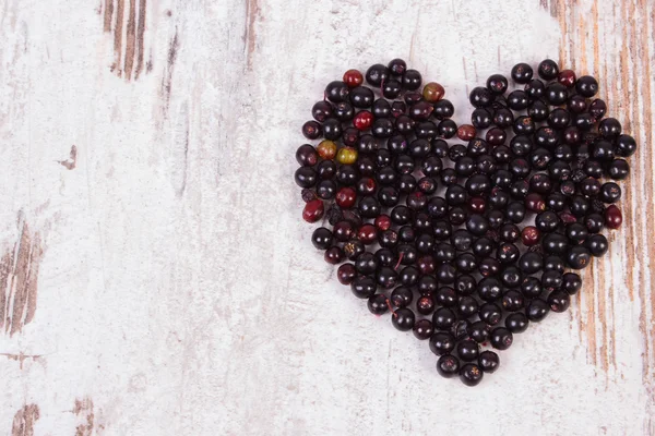 Heart of elderberry on wooden background, symbol of love, copy space for text — Stok fotoğraf