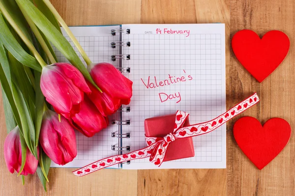 День Святого Валентина, написаний на ноутбук, свіжі тюльпани, загорнуті подарунок і серце, прикраси для Валентина — стокове фото