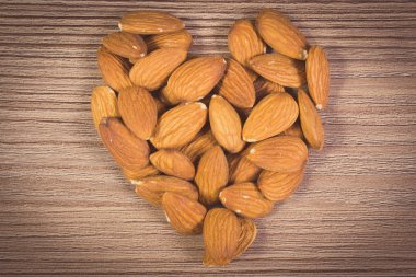 Vintage photo, Heart of almonds on wooden background