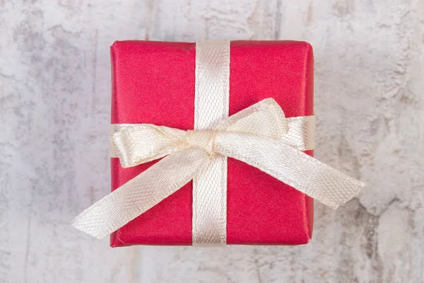 Red gift for Valentine or other celebration on wooden plank — ストック写真