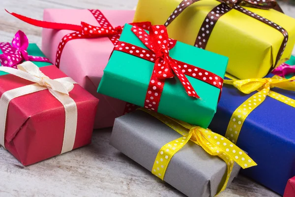 Wrapped colorful gifts for Valentine or other celebration on old white plank — Stockfoto