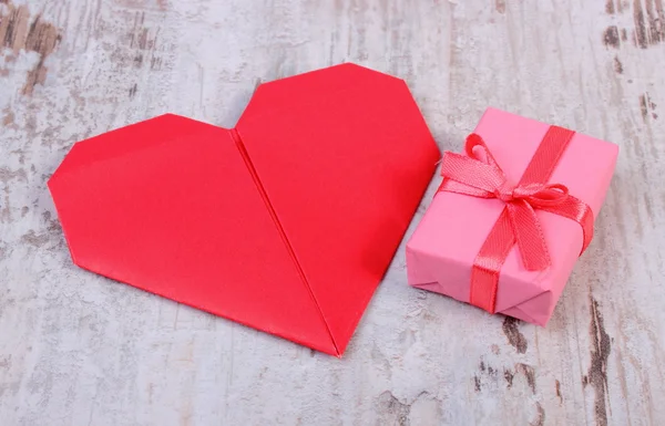 Regalo envuelto para cumpleaños, San Valentín u otra celebración y corazón rojo — Foto de Stock