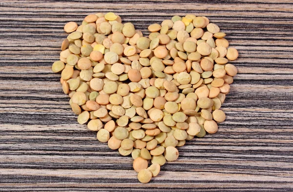 Heart of green lentil on wooden background — 스톡 사진