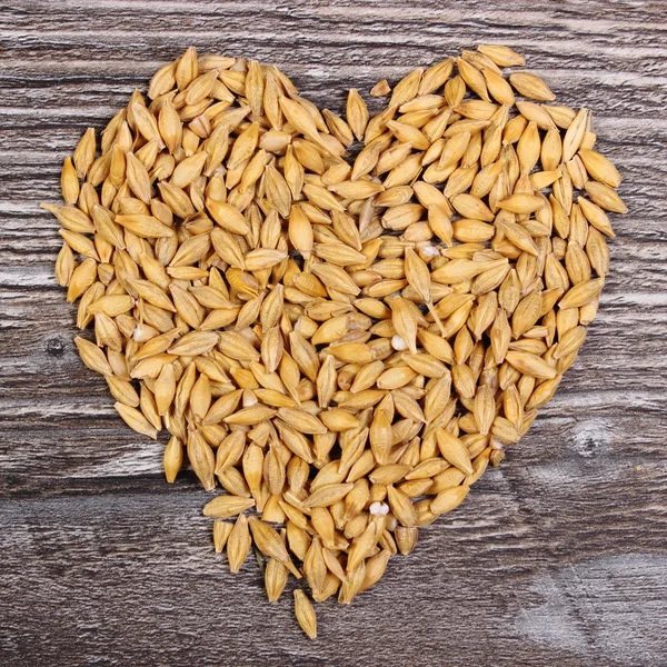 Heart of barley grain on wooden background — Stock Photo, Image