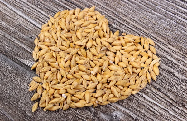 Heart of barley grain on wooden background — Stock Photo, Image