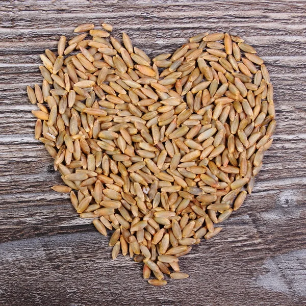 Heart of rye grain on wooden background — Stock Photo, Image
