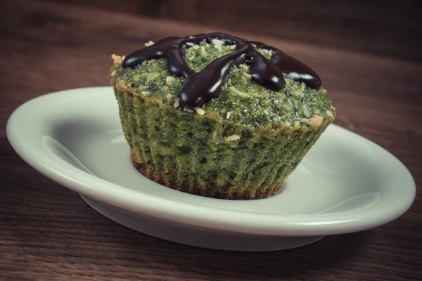 Jahrgangsfoto, frischer Muffin mit Spinat, Kokosraspeln und Schokoladenglasur, leckeres gesundes Dessert — Stockfoto