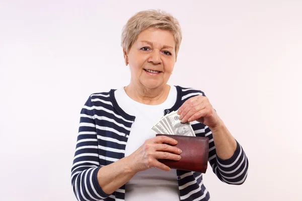 Счастливая старшая женщина держит кошелек с валютой доллар, концепция финансовой безопасности в старости — стоковое фото