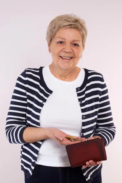 Gelukkig senior vrouwelijke holding munten en lederen portemonnee, concept van financiële zekerheid in de ouderdom — Stockfoto