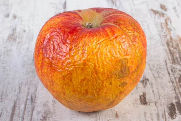 Bortskämd äpple på gamla vita träbord — Stockfoto