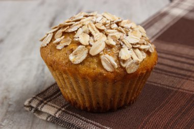 Kepekli un üzerinde damalı masa örtüsü, lezzetli sağlıklı tatlı taze muffin yulaf ezmesi ile pişmiş