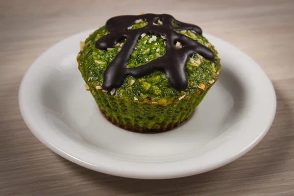 Frischer Muffin mit Spinat, Kokosraspeln und Schokoladenglasur, leckeres gesundes Dessert — Stockfoto
