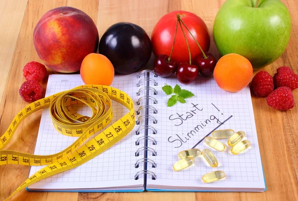 Owoce, tabletek suplementów i centymetr z notebooka, odchudzania i zdrowego jedzenia — Zdjęcie stockowe