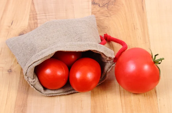 Tomates fraîches dans un sac de jute sur une surface en bois, mode de vie sain et nutrition — Photo