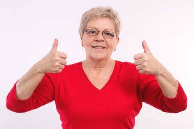 Happy smiling elderly woman showing thumbs up, positive emotions in old age