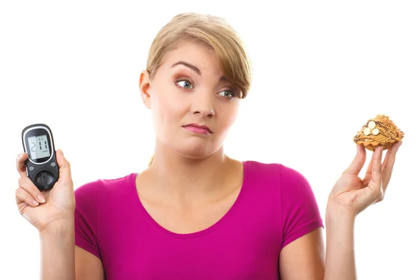 Shocked woman holding glucometer and fresh cupcake, measuring and checking sugar level, concept of diabetes — ストック写真