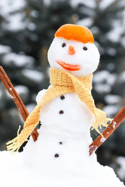 Snowman with woolen scarf and tangerine peel, winter season concept — Stockfoto