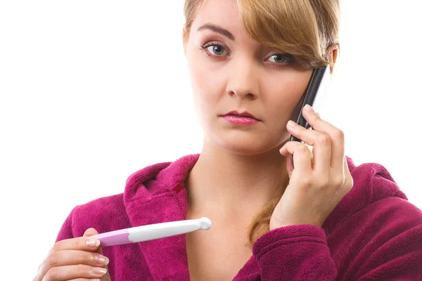 Worried woman with phone informing someone about positive pregnancy test Stock Image