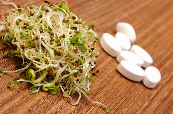 Проростки люцерни та редиски з таблетками, здорове харчування — стокове фото