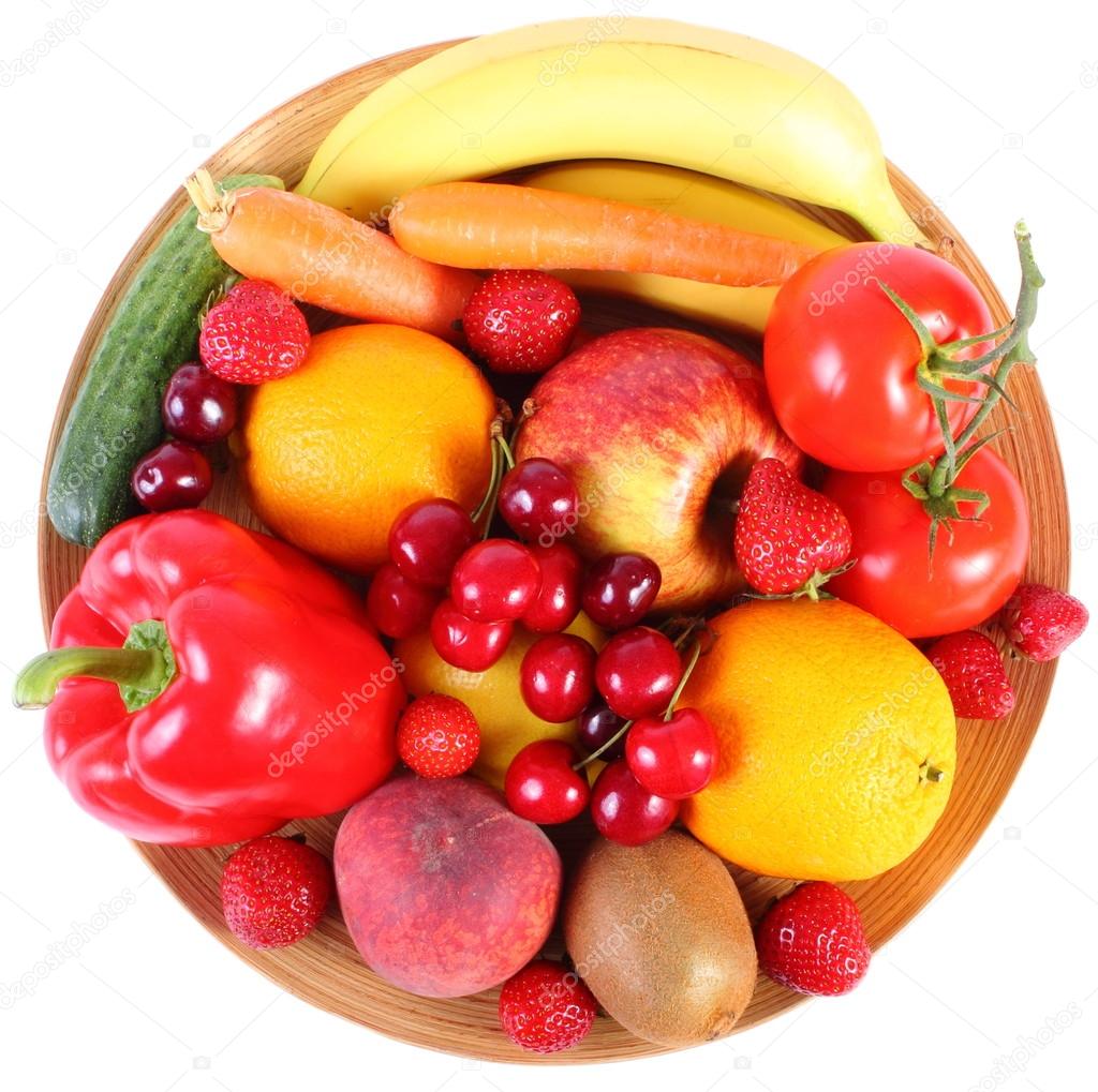 Fresh fruits and vegetables on wooden plate